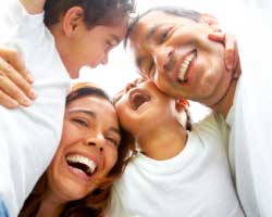 Two adults laughing together with two children