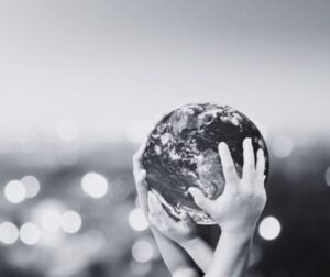 a black and white image of people holding a globe together